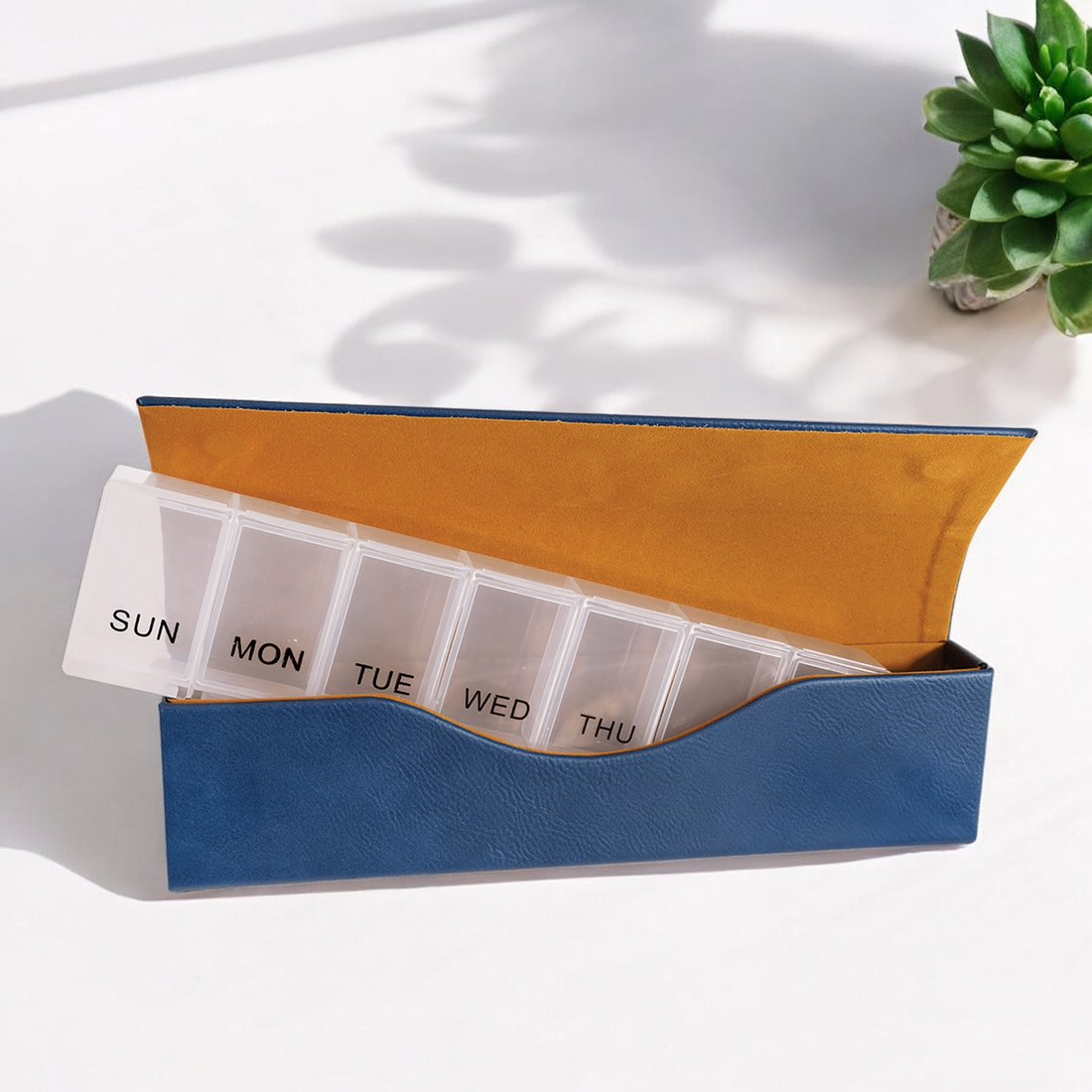Custom Laserable Leatherette Pill Box with Weekly Organizer, featuring a sleek design with seven large compartments labeled for each day of the week, displayed in pink, rawhide, and gray leatherette cases with a magnetic closure. Ideal for corporate branding, travel, and personal use.