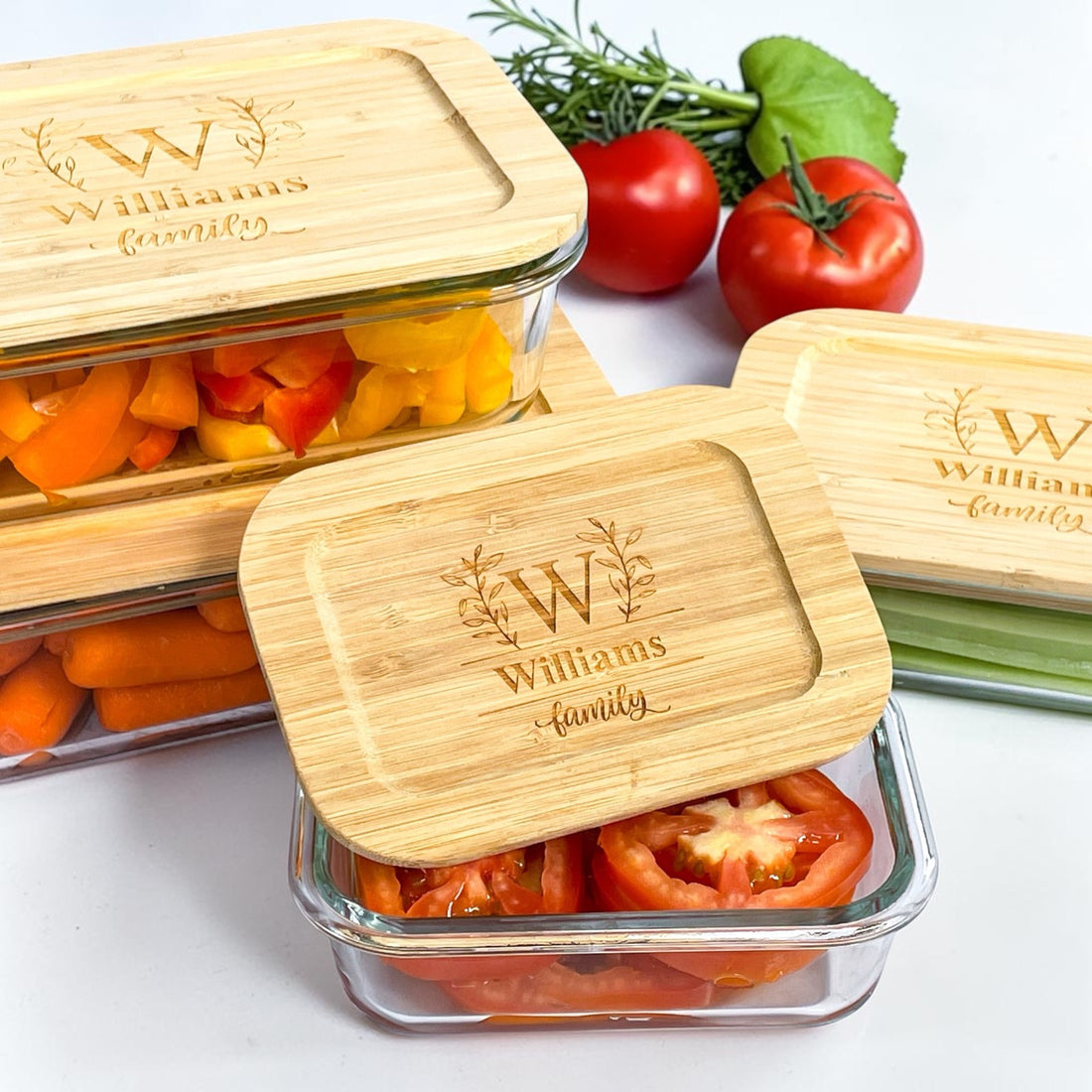 Personalized glass food storage container set with engraved bamboo lids displayed with fresh vegetables. Elegant realtor closing gift and luxury housewarming gift idea for new homeowners, kitchen organization, meal prep, sustainable food storage, and personalized client appreciation gifts.