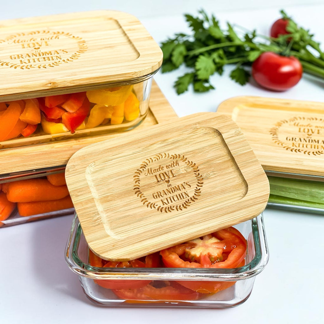 Personalized glass food storage container set with engraved bamboo lids styled with fresh vegetables in a modern kitchen setting. Eco-friendly kitchen organization containers designed for realtor closing gifts, luxury housewarming gifts, and new homeowner gift baskets.