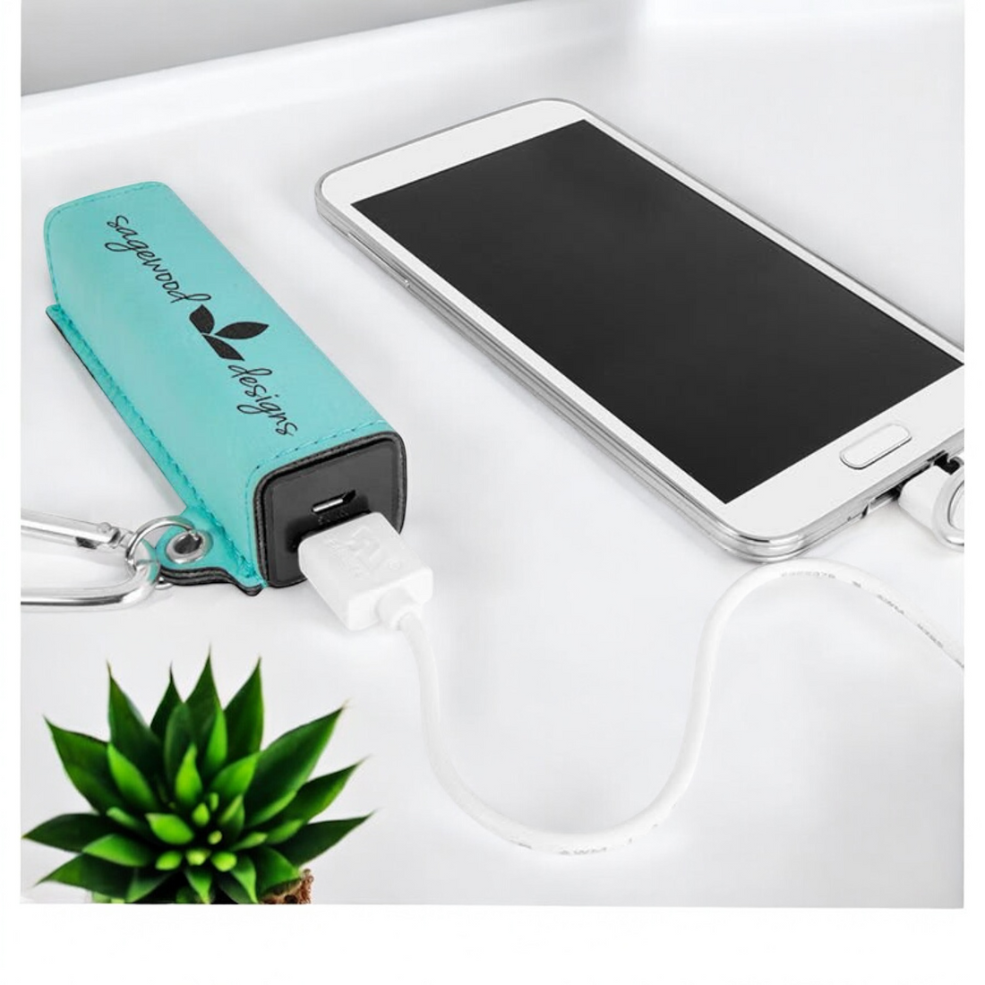 Custom laser-engraved leatherette 2200mAh power bank with silver carabiner and USB cord, ideal for corporate branding and promotional gifts.