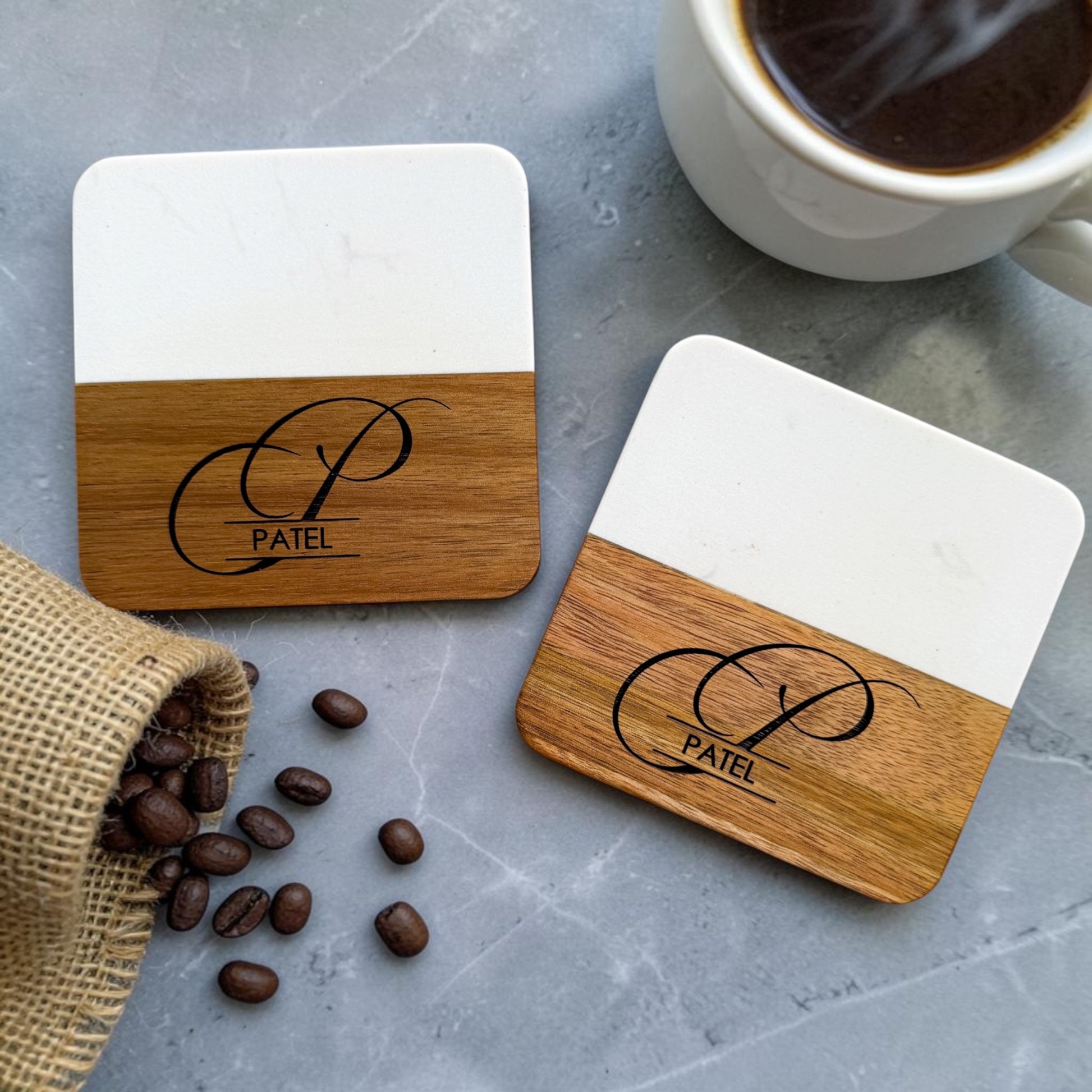 Personalized marble and acacia wood coasters engraved with monogram and family name styled with coffee cup and coffee beans for luxury kitchen décor and realtor closing gifts