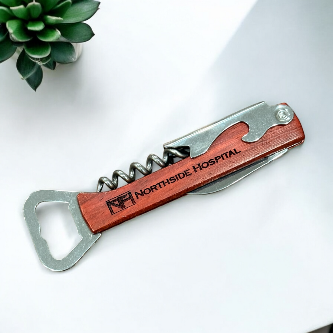 Wooden bottle opener and corkscrew multi-tool with stainless steel components, displayed in both folded and open positions. Features a personalized wooden handle, ideal for corporate branding and gifting.